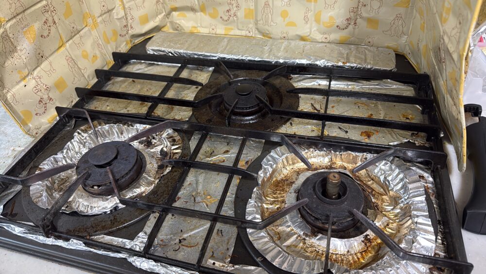 キッズラインの家事代行を使う直前の我が家の3口ガスコンロ。炒めたものが落ちていたり油汚れのひどい様子が伝わってっくる写真。ビフォーアフターのビフォアー