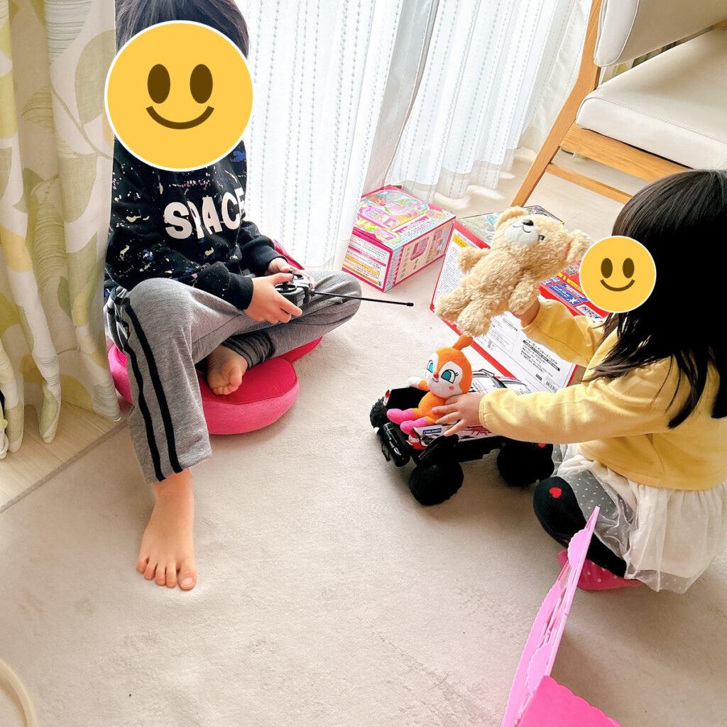 自宅の床でラジコンとぬいぐるみで遊ぶわが家の兄と妹